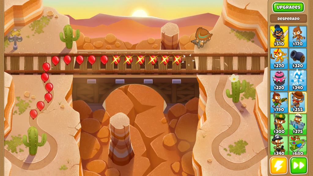 Bloons TD 6 게임 화면, 황량한 사막 배경에 기차 선로와 풍선이 설정되어 있으며, 다양한 캐릭터와 업그레이드 옵션이 표시된 오른쪽 패널이 포함되어 있습니다.
