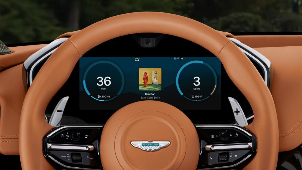 A close-up view of a luxury car's steering wheel and dashboard, featuring a modern display showing speed, distance to empty, and current driving mode, all set against a leather interior.