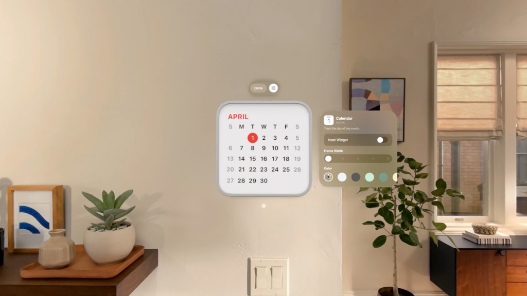 A spatial calendar widget displaying the month of April in a modern living room setting with indoor plants and decorative items.