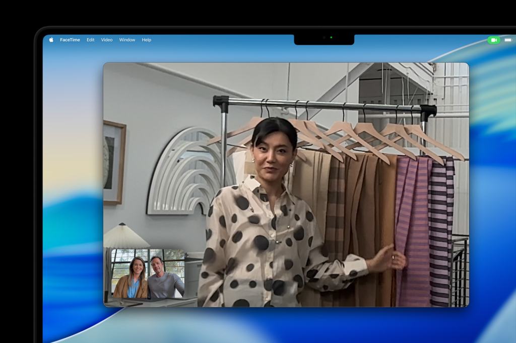 MacBook Pro 14에서 FaceTime을 사용하여 대화 중인 두 사람과 함께 화면에 나타난 인물과 여러 개의 천이 걸린 의상 행거.
