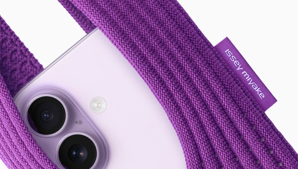 보라색 ISSEY MIYAKE iPhone Pocket에 감싸인 iPhone 뒷면, 카메라 렌즈와 조명 장치가 보임.