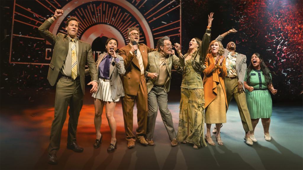 2025년, 기록적인 한 해를 보낸 Apple 서비스 7 무대에서 함께 노래하며 즐거운 모습을 보이는 여러 명의 사람들. 각기 다른 의상을 입고 있으며, 기쁜 표정을 짓고 있다.