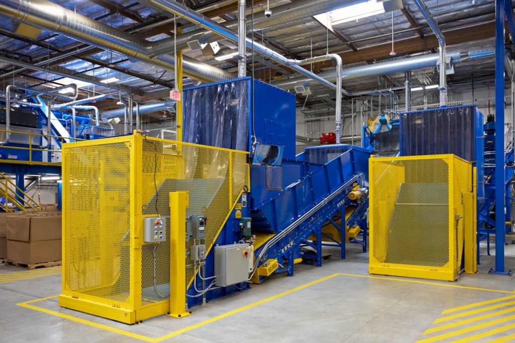 산업용 기계가 있는 공장의 내부 모습, 노란색 안전망과 여러 개의 파이프가 보이는 현대적인 설비.