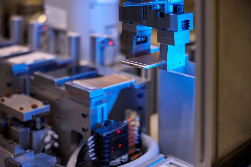 정밀 기계 부품과 로봇 팔이 있는 공장 내부 모습